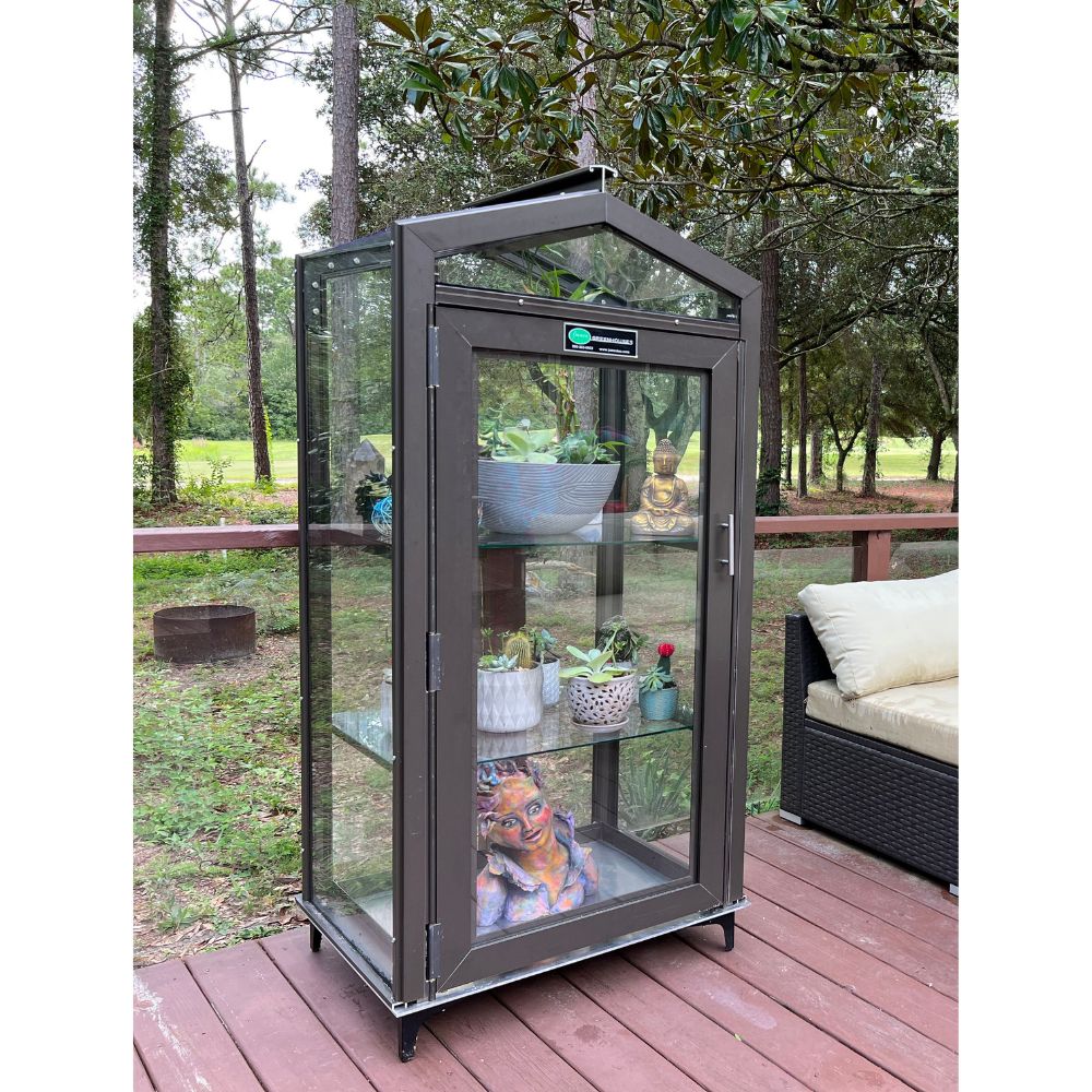 Bronze Janco Garden Curio outdoors with door closed and plants displayed on adjustable glass shelves