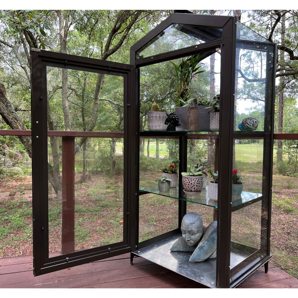 Janco Garden Curio in bronze outdoors with glass door open and adjustable plant shelves