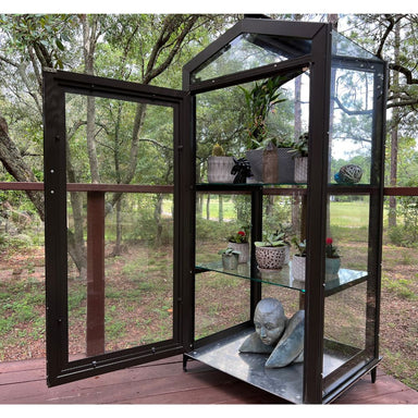 Janco Garden Curio in bronze outdoors with glass door open and adjustable plant shelves