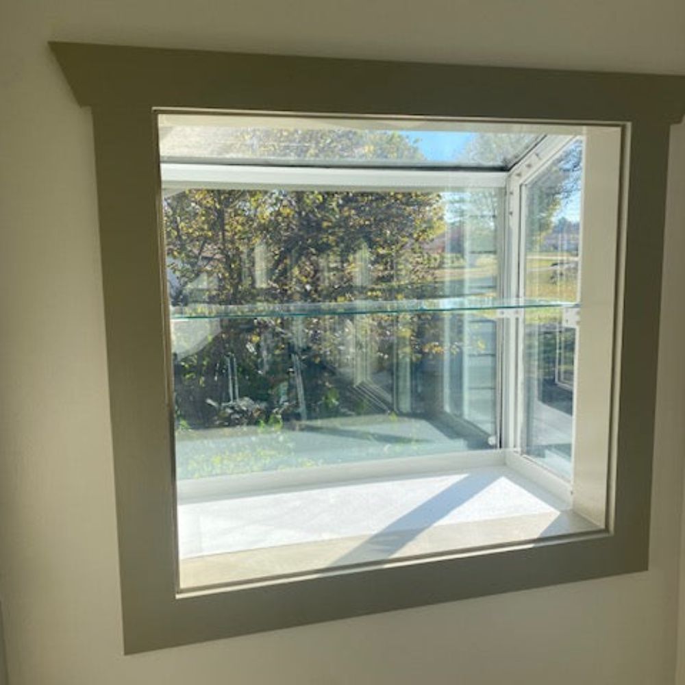 Large Janco Garden Window with empty glass shelf installed and mounting brackets visible