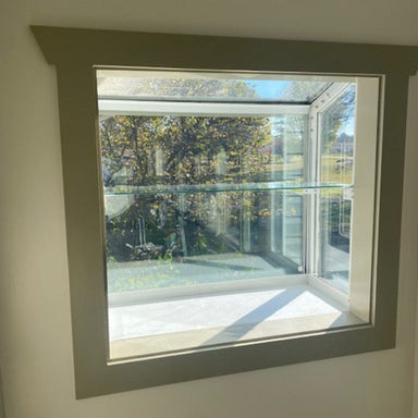 Large Janco Garden Window with empty glass shelf installed and mounting brackets visible