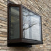 Bronze Janco Garden Window installed on a stone exterior wall
