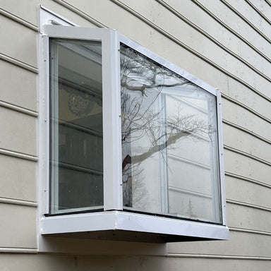 White Janco Garden Window installed on exterior siding, shown from an angled view