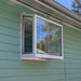 White Janco Garden Window installed on a green-sided home exterior, shown from an angled view
