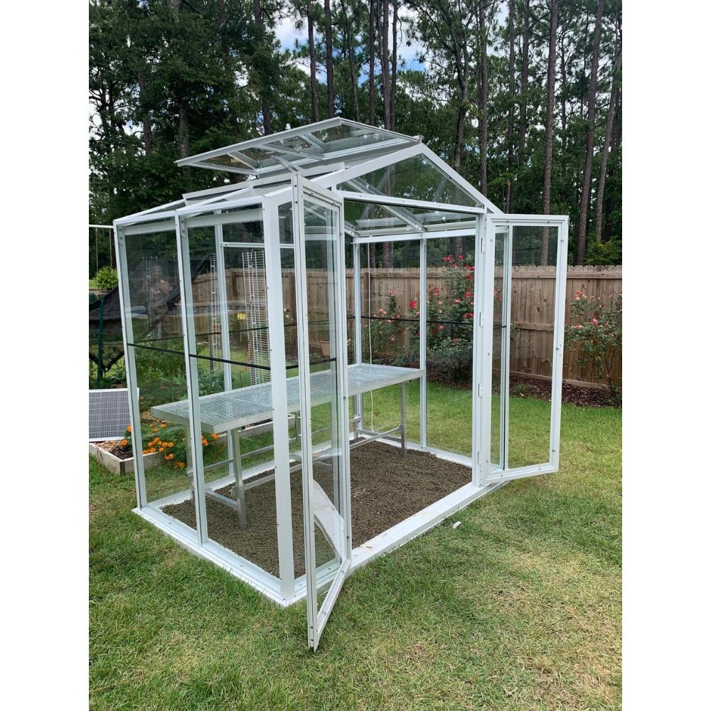 Janco Sago 5' x 8' glass greenhouse with white frame, double doors open and optional interior bench