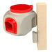Beige and red chicken feeder and mounting bracket on a wooden board.
