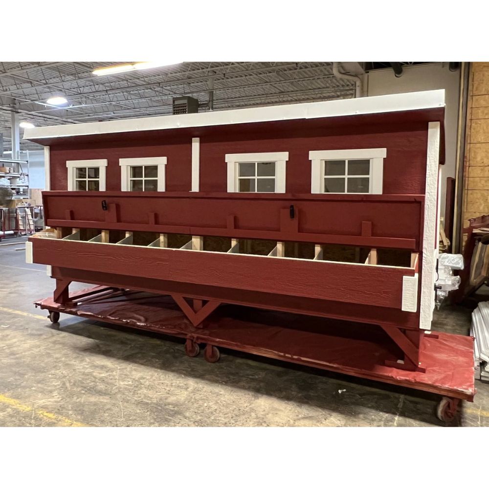 Red and white wooden chicken coop with open nesting box door and 10 nesting boxes.