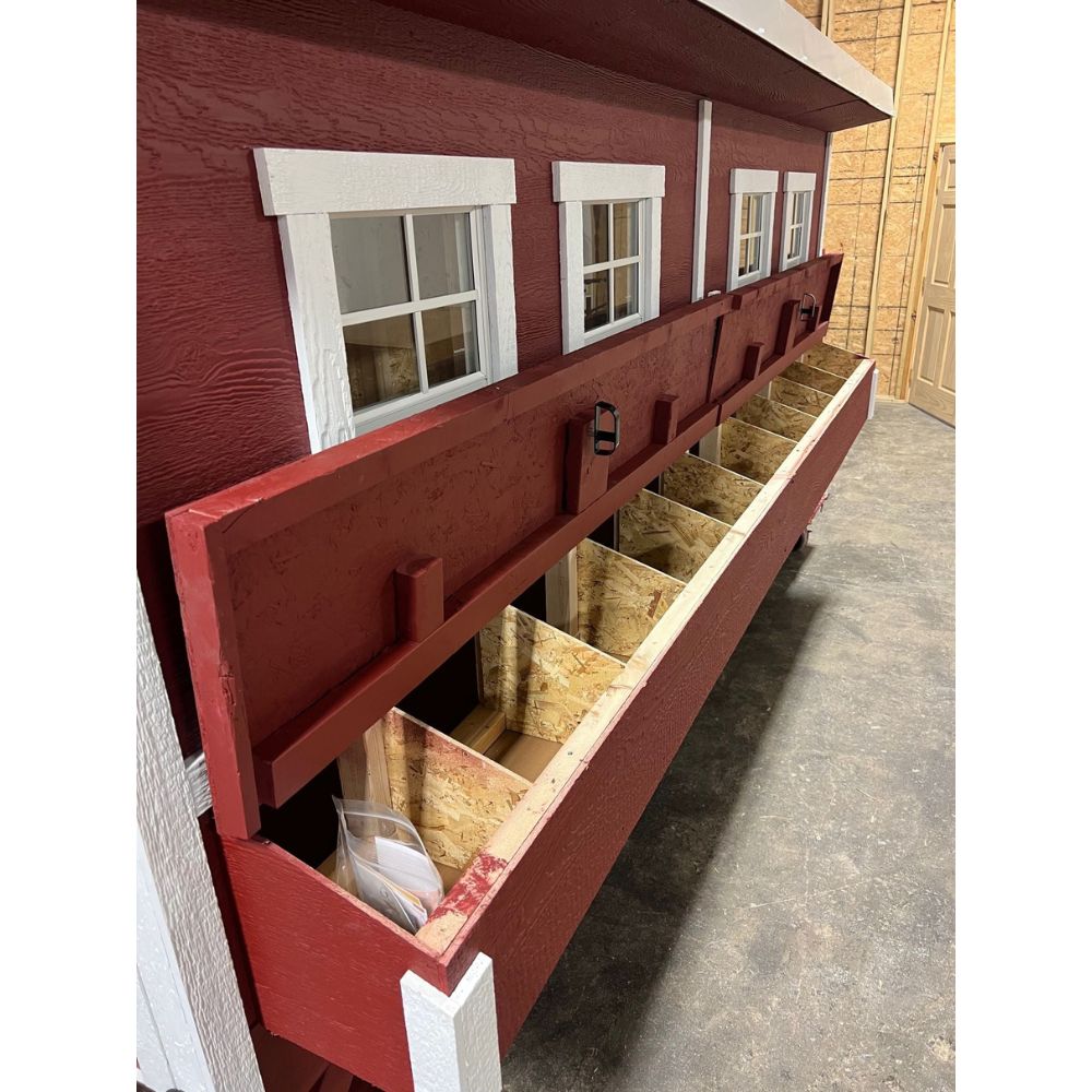 Red and white chicken coop, side view of 10 nesting boxes with door open.