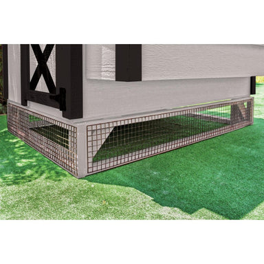 White wooden panels with black mesh elevating a chicken coop on astroturf.