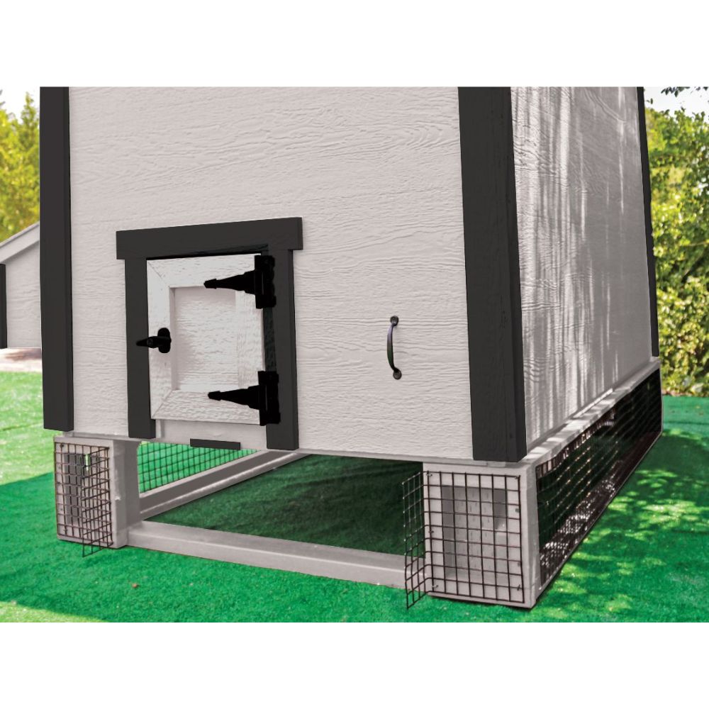 A white and black elevated chicken coop with a wire bottom and side panels, shown outdoors on artificial green turf with trees in the background.
