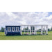 Blue and white wooden chicken coop with attached white wooden run, outside in the grass with 3 chickens.