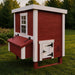 Red and white wooden chicken coop, outside at dusk.