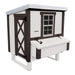 White and black chicken coop with a nesting box and large entry door.