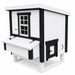 White and black chicken coop with one window, a nesting box, and chicken door.