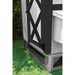 Corner picture of wooden panels with black mesh elevating white chicken coop.