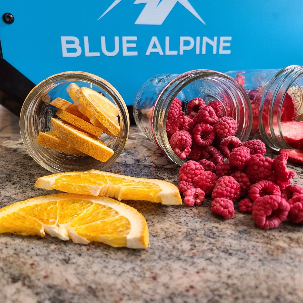Freeze dried ranges and raspberries spilling out of jars with 'Blue Alpine' branding in the background.