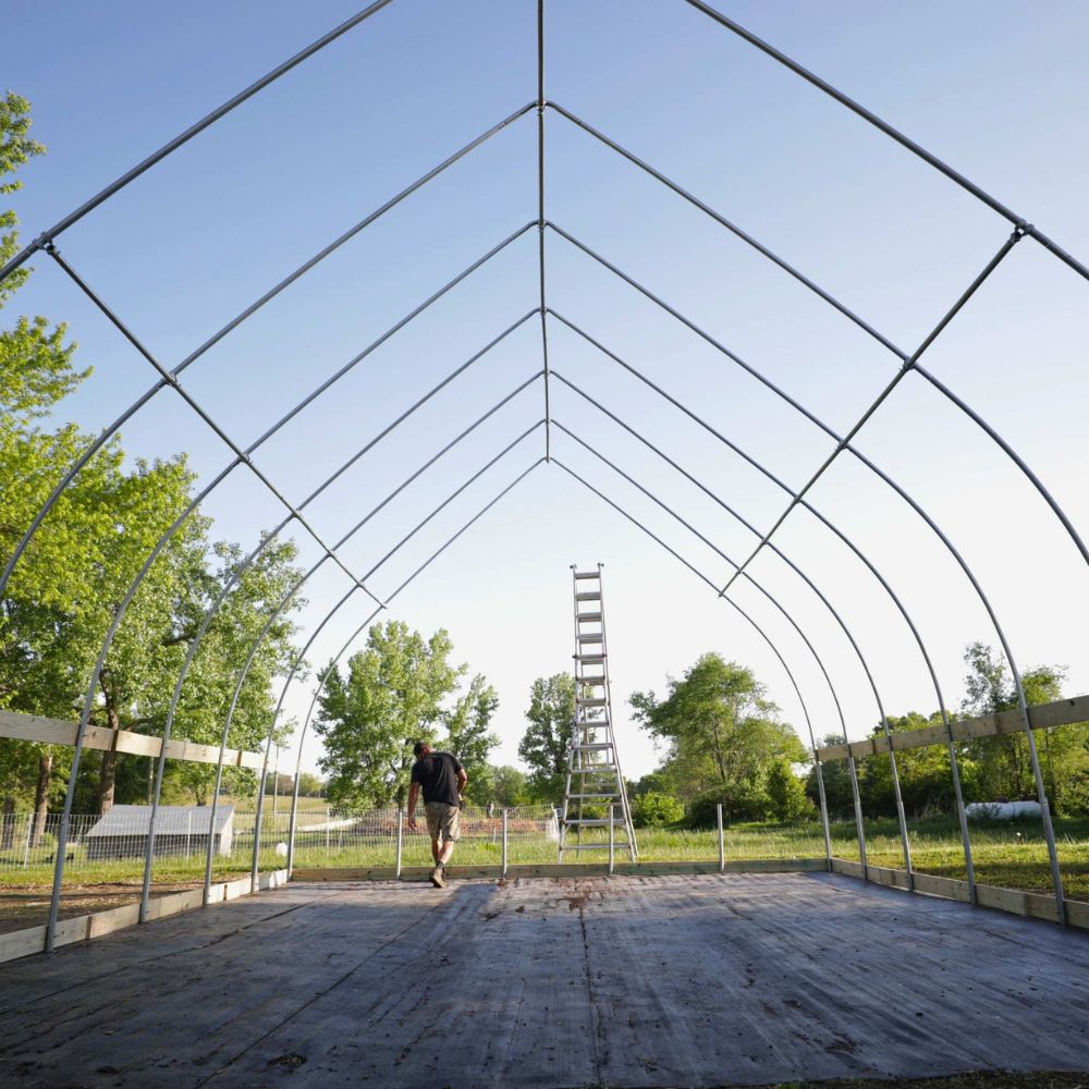 Bootstrap Farmer DIY Gothic Greenhouse during construction showing the tall Gothic arch metal frame before the greenhouse plastic is installed