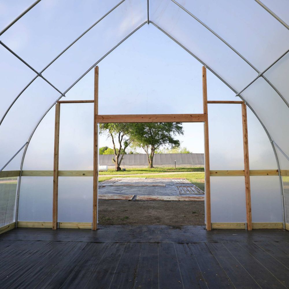 Interior view of the Bootstrap Farmer DIY Gothic Greenhouse showing the peaked Gothic frame and locally sourced wood framing