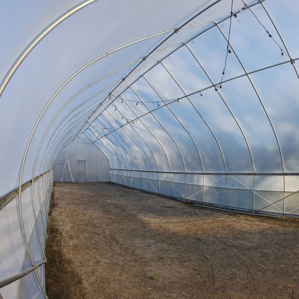 Angled view of the interior of the Bootstrap Farmer Gothic High Tunnel showing a single door.