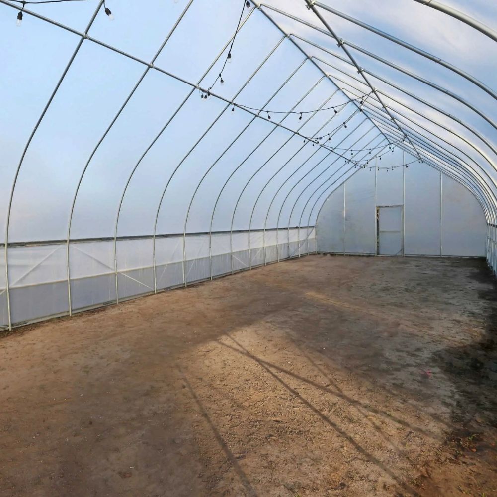 Interior of the Bootstrap Farmer Gothic High Tunnel with a dirt floor.