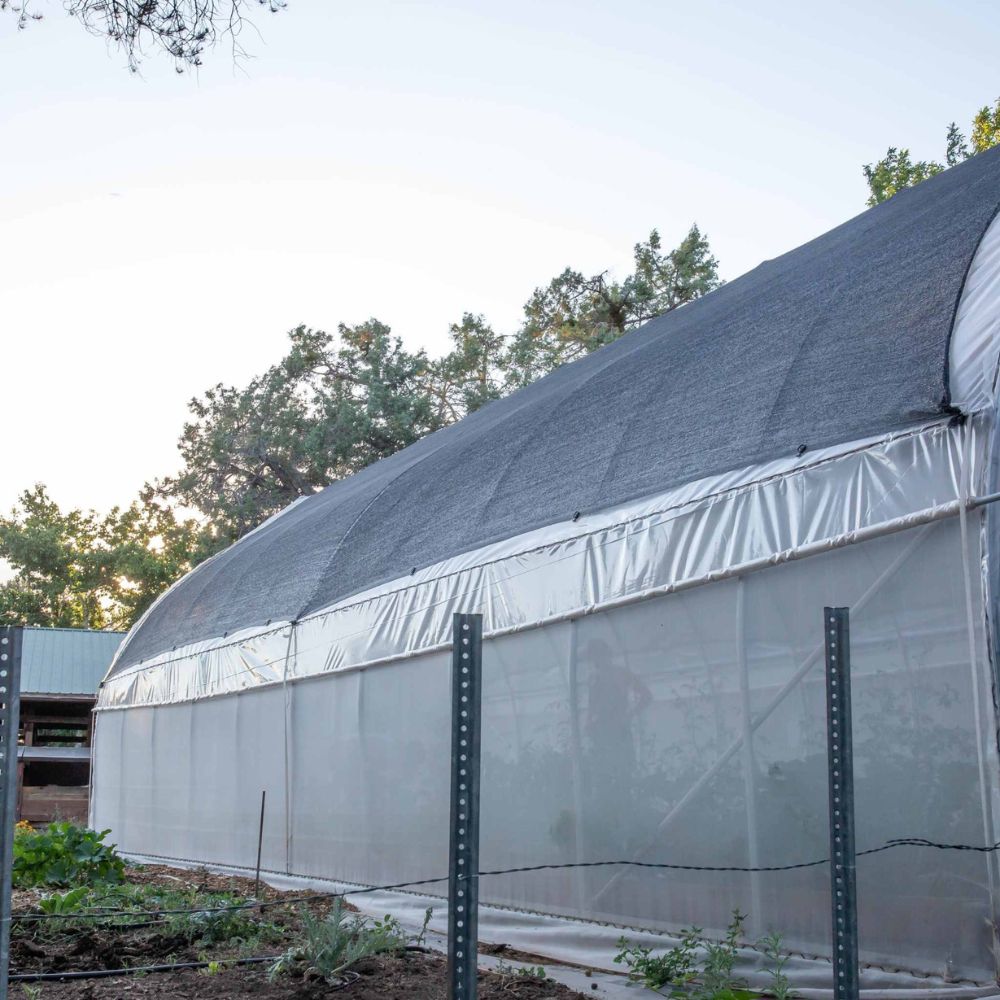 Outside of the Bootstrap Farmer Gothic High Tunnel with the optional roll up sides and shade cloth.
