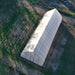 Overhead angled view of the Bootstrap Farmer Gothic High Tunnel, sun and shadows stretching across the grass.